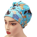 Front view of a light blue bouffant surgical cap with colorful cartoon dogs print