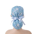 Light blue floral and white puppy  print ponytail scrub cap with satin ribbon bow and wooden buttons, back view on mannequin
