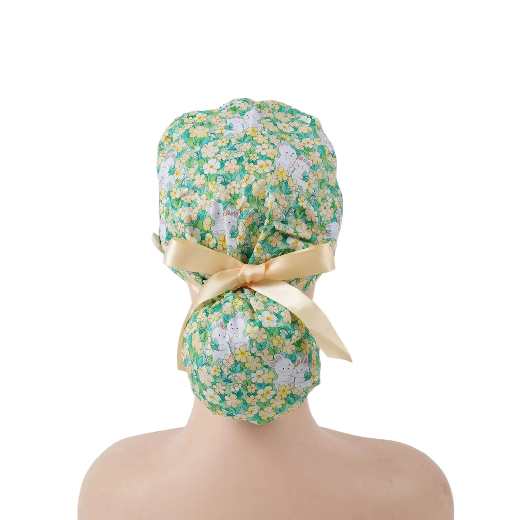 Green bunny and floral print ponytail scrub cap with yellow satin ribbon bow, back view on mannequin