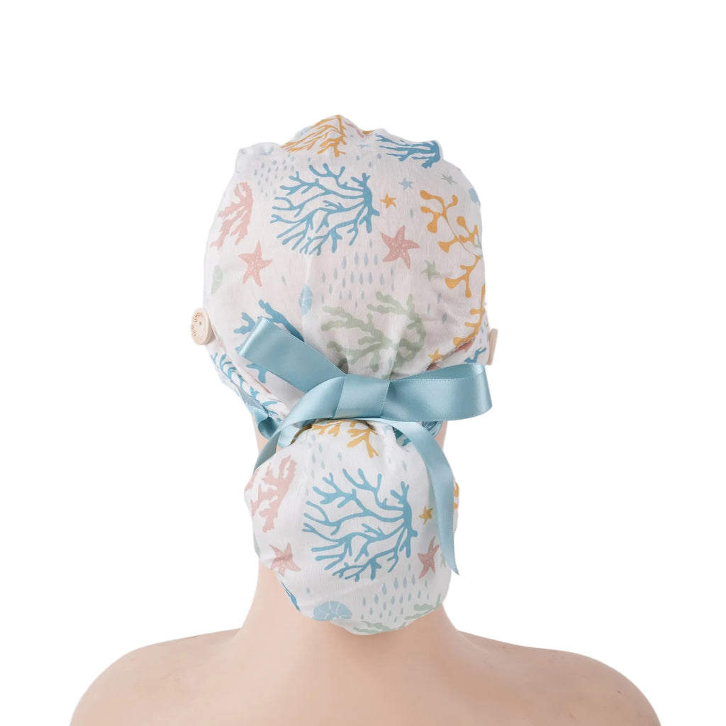 A ponytail scrub cap with coral, starfish print, tied with a light blue satin ribbon at the back.