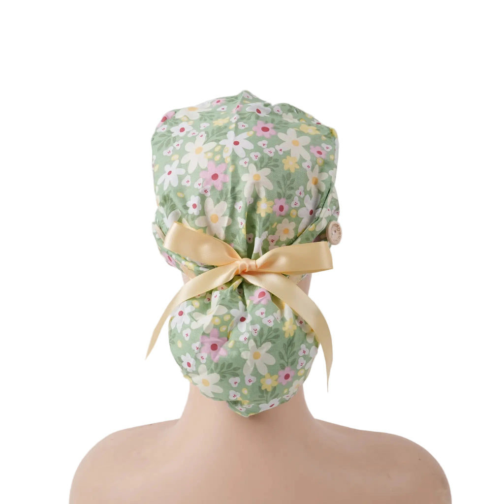 back view on mannequin of sage green daisy floral scrub cap with yellow satin ribbon bow.