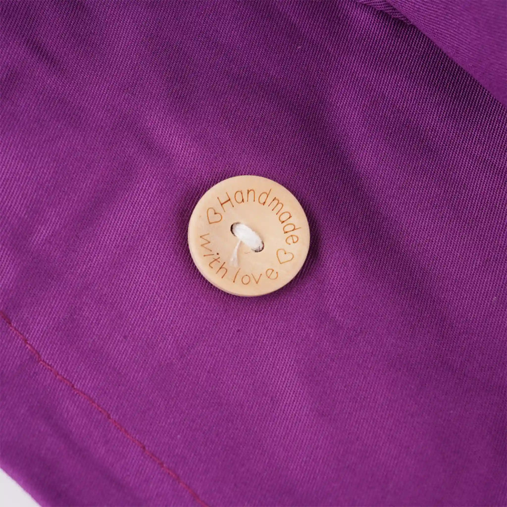 A close-up of the wooden  mask button engraved with the words 'Handmade with love' and small heart details.