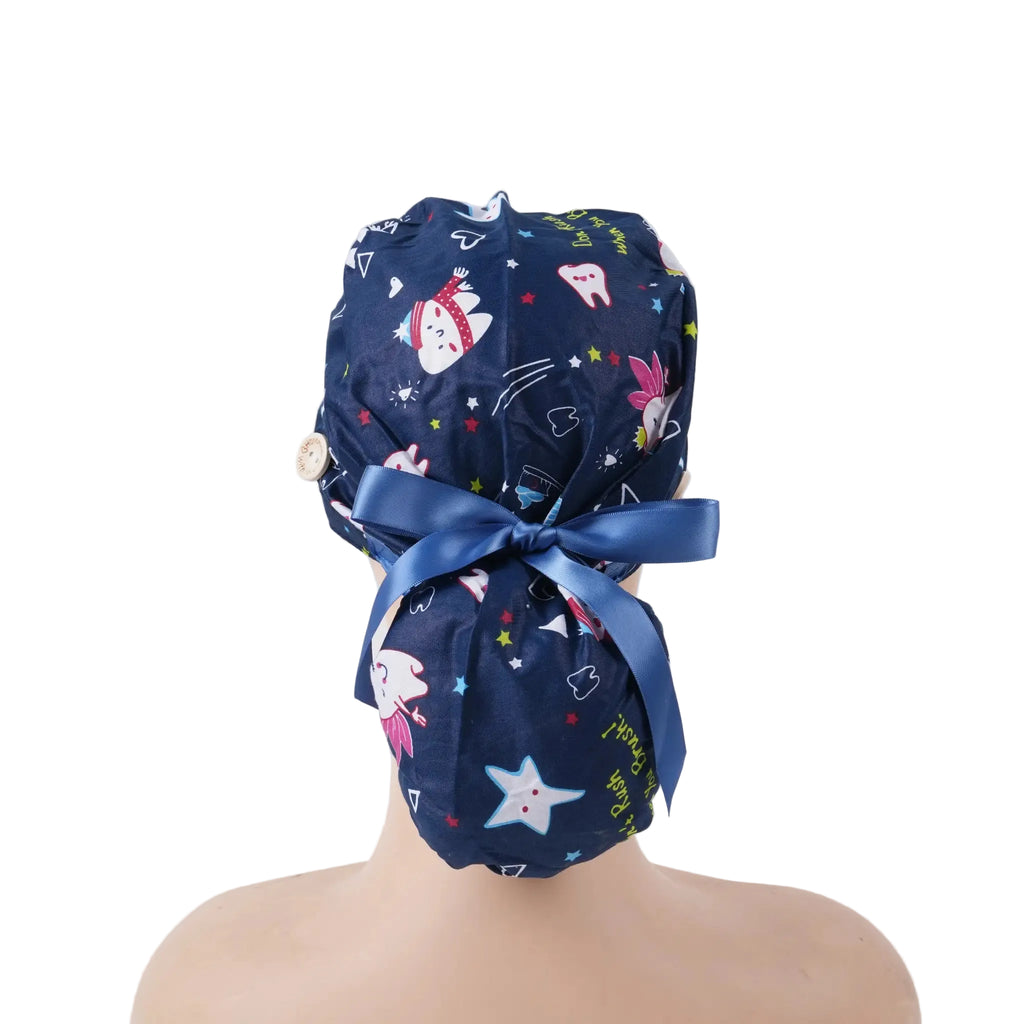 Navy blue dental-themed scrub cap with cartoon tooth, rabbit, and star prints, satin ribbon bow at back