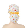 White multi-color ditsy floral scrub cap with yellow satin ribbon bow and wooden button, back view on mannequin