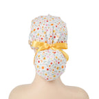White multi-color ditsy floral scrub cap with yellow satin ribbon bow and wooden button, back view on mannequin