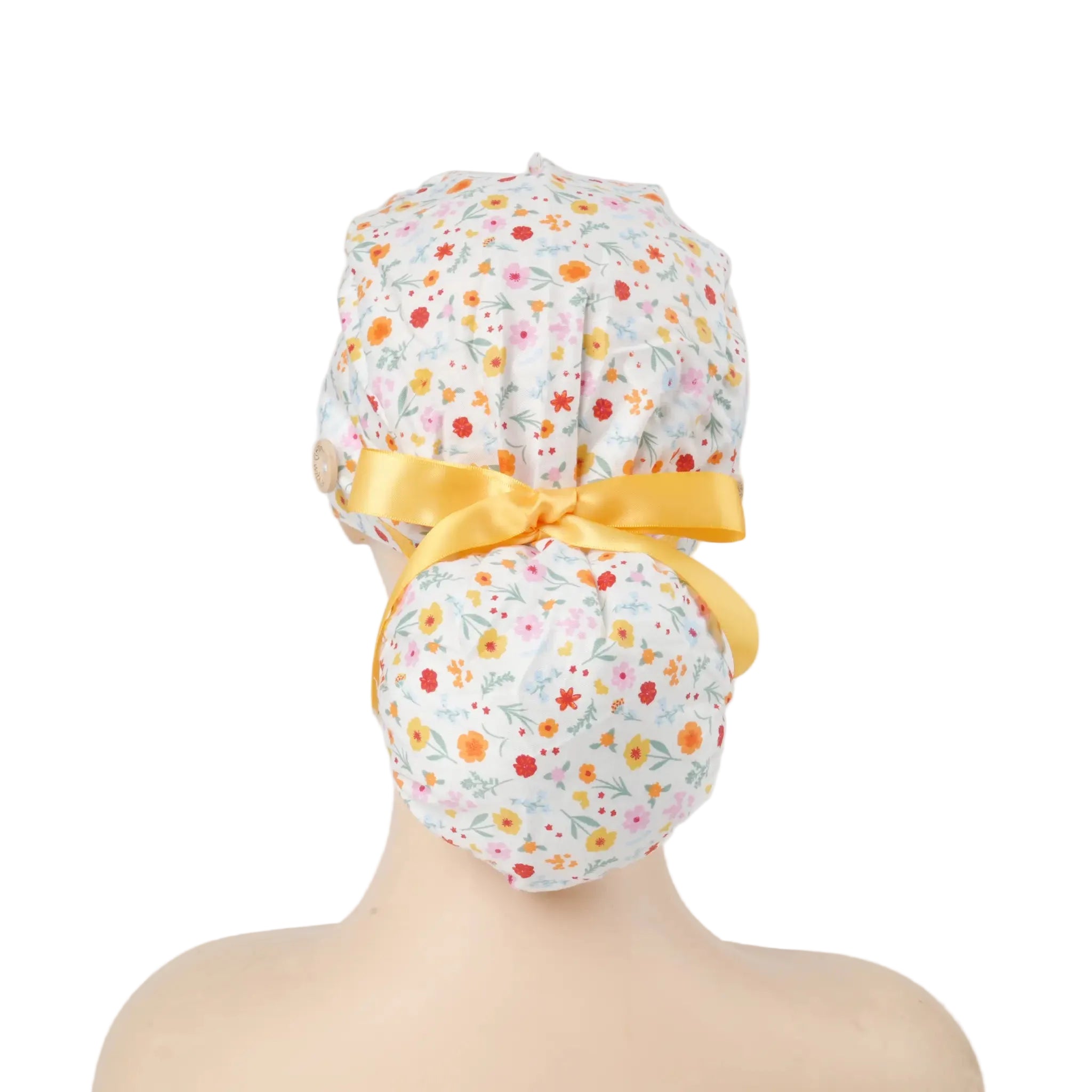 White multi-color ditsy floral scrub cap with yellow satin ribbon bow and wooden button, back view on mannequin