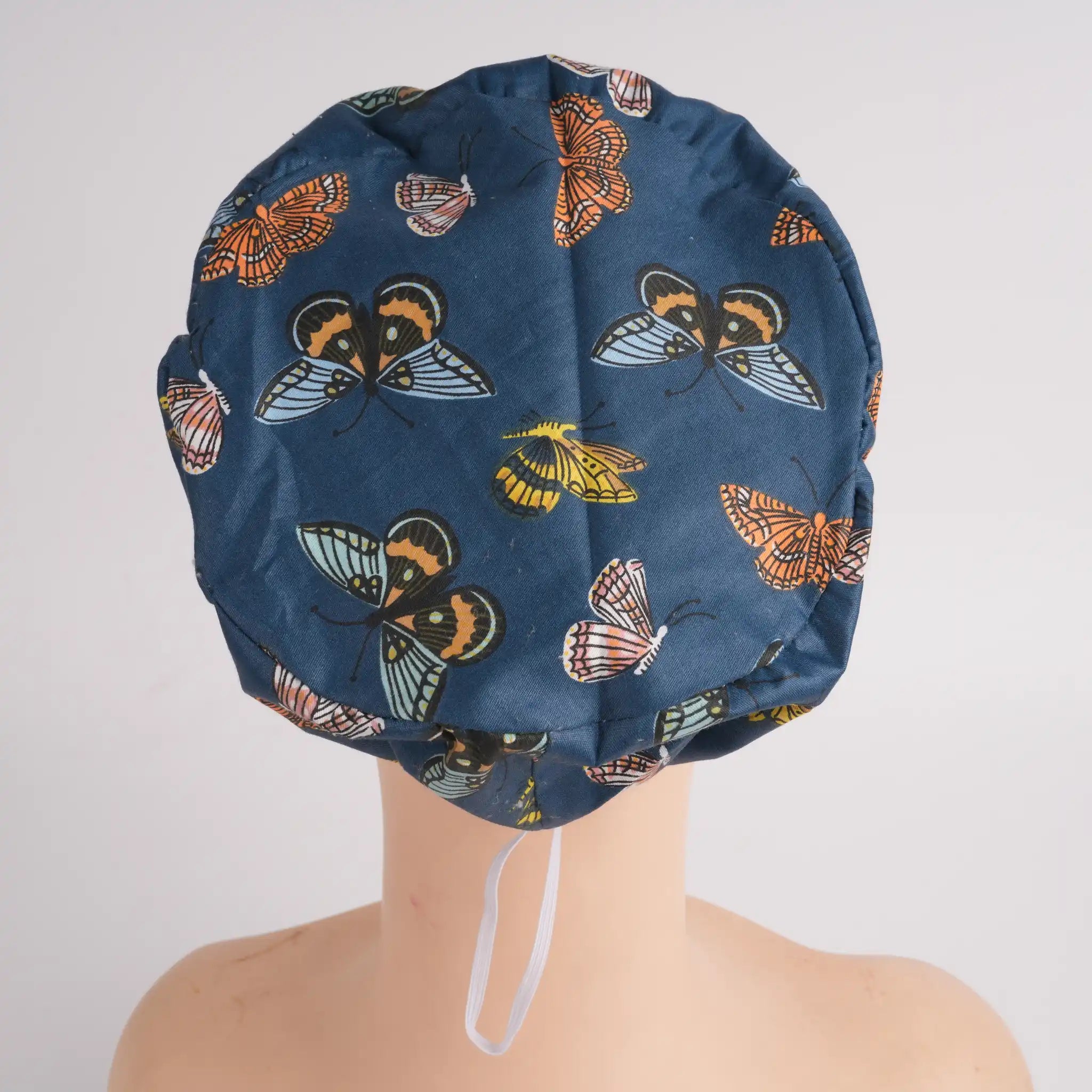Back view of navy butterfly euro cap on mannequin head