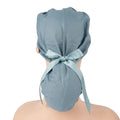 A gray blue cotton ponytail surgical scrub cap shown from the back on a mannequin head, tied with a matching satin ribbon bow.