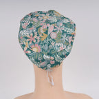 Back view of teal green floral euro cap on mannequin head.