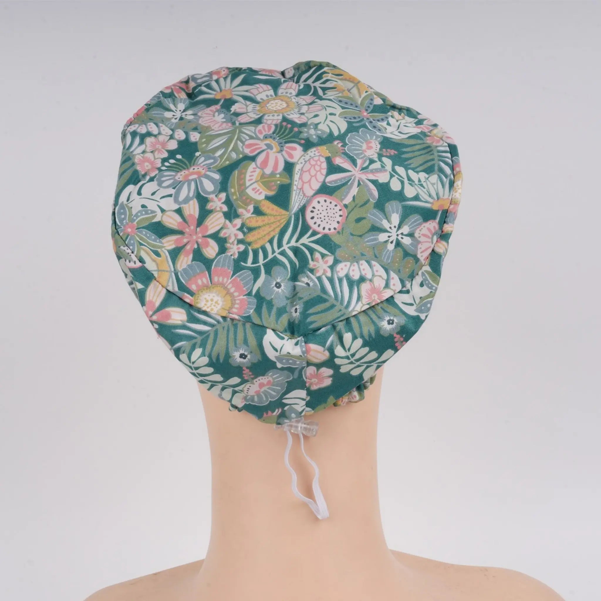 Back view of teal green floral euro cap on mannequin head.