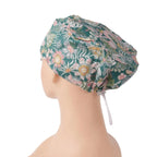 A euro scrub cap in teal green with pink, white, and yellow flowers, shown on a mannequin head.