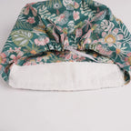 Close-up of forehead sweatband on teal green floral euro cap.