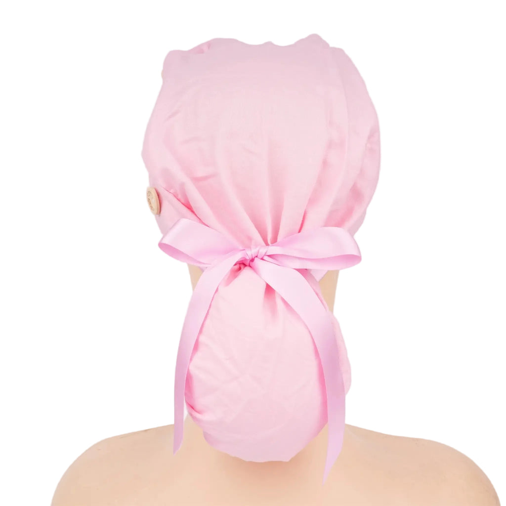 A light pink ponytail cap with light pink ribbon tail tied in a bow, shown on a mannequin head from the back.