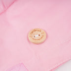 Close-up of a wood button engraved with the words 'Handmade' and heart details.