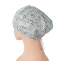 Left side view of mint floral euro cap on mannequin head, adjustable toggle in back.