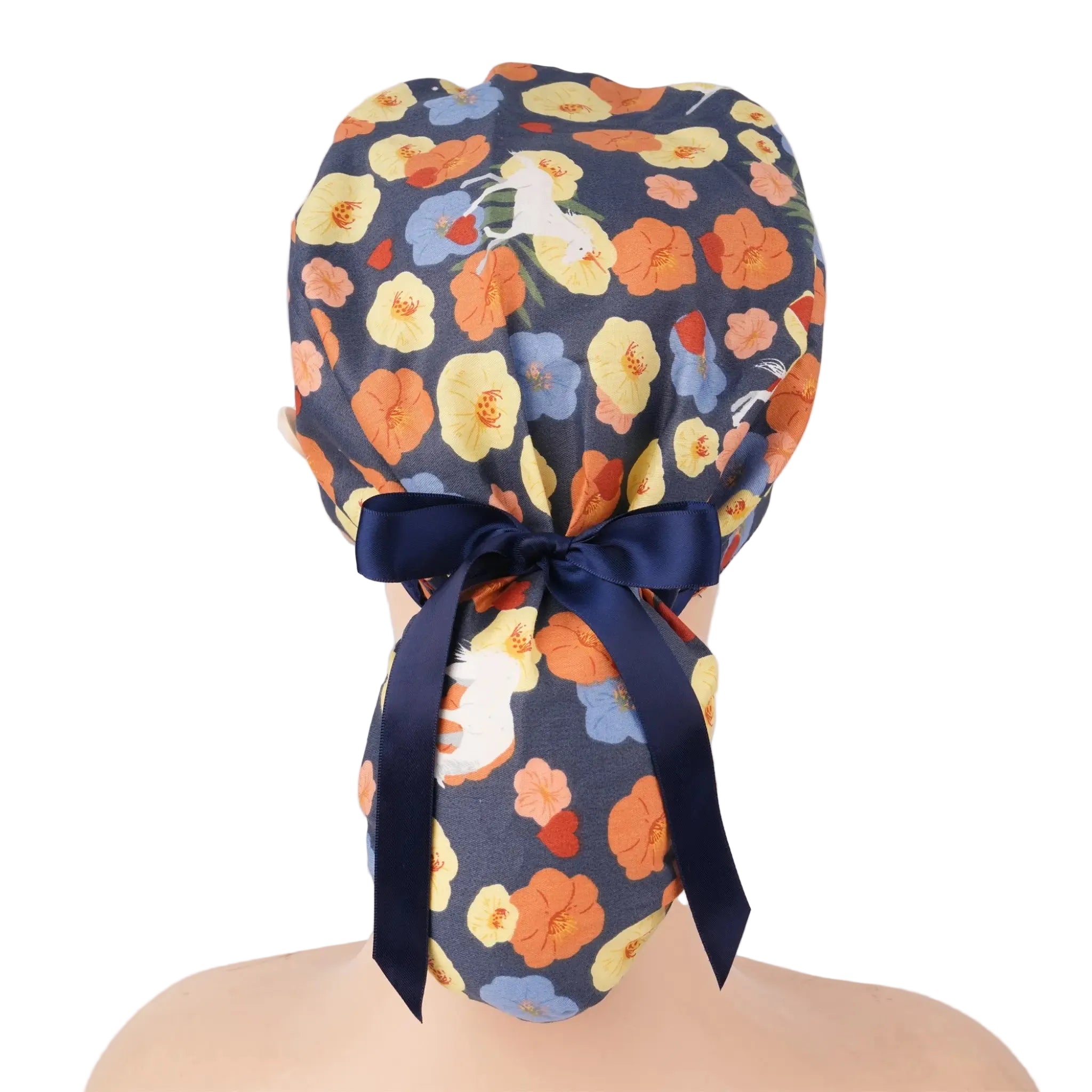A floral patterned ponytail scrub cap with a navy blue satin bow, displayed on a mannequin head.