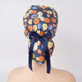 A floral patterned ponytail scrub cap with a navy blue satin bow, displayed on a mannequin head.