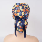 A floral patterned ponytail scrub cap with a navy blue satin bow, displayed on a mannequin head.
