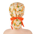 Orange with white daisies ponytail scrub cap, displayed on a mannequin head.