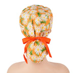 Orange with white daisies ponytail scrub cap, displayed on a mannequin head.