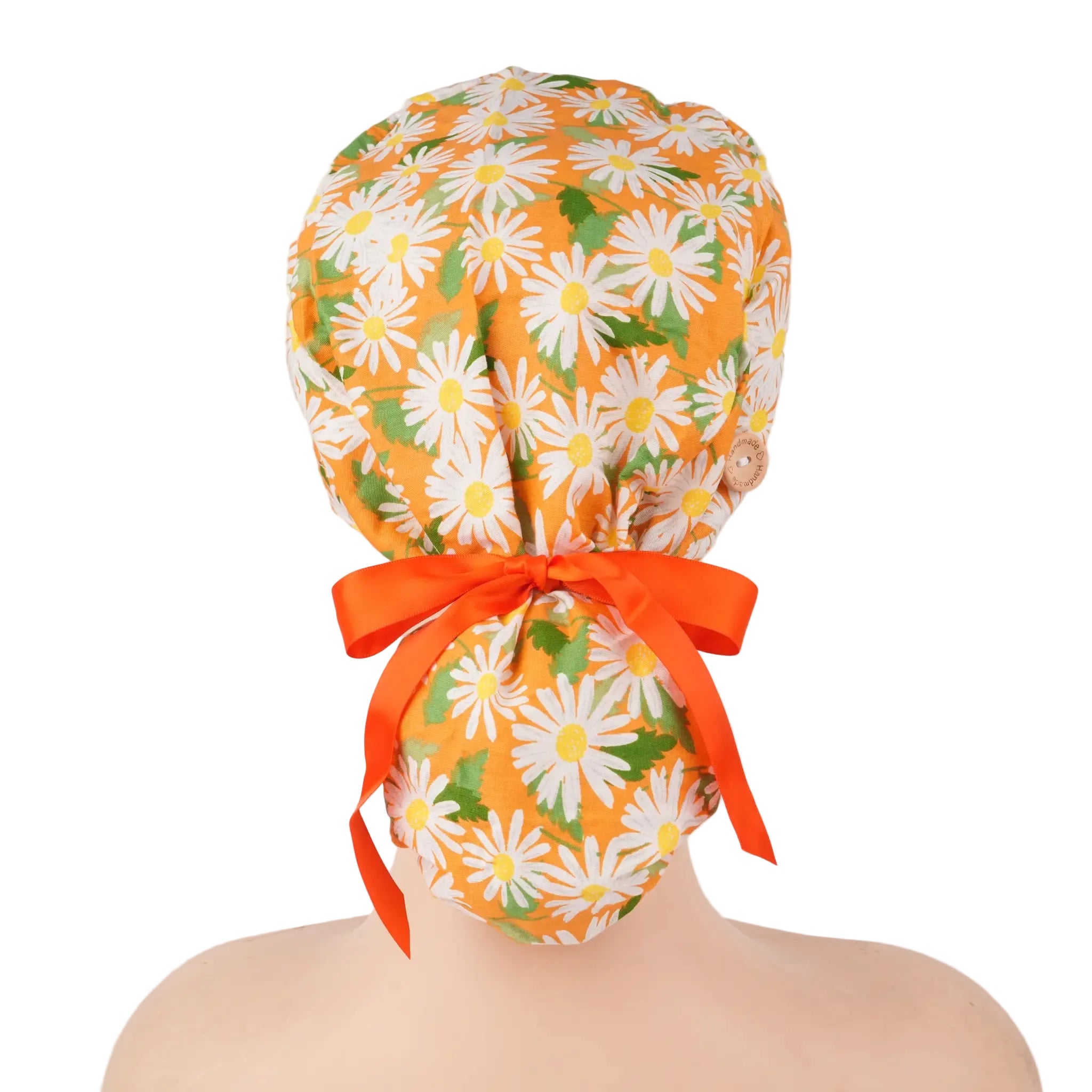 Orange with white daisies ponytail scrub cap, displayed on a mannequin head.