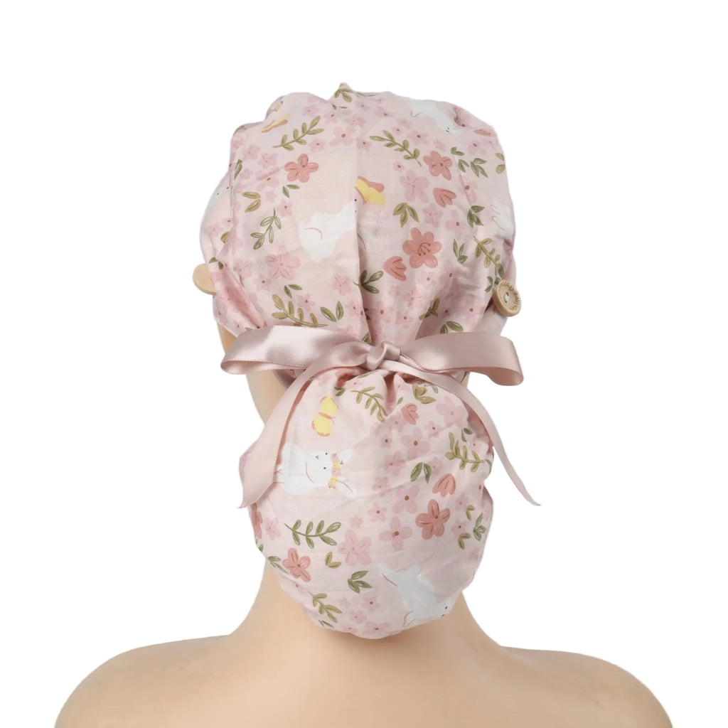 Pink bunny and florals ponytail scrub cap with dusty pink satin ribbon bow, back view on mannequin