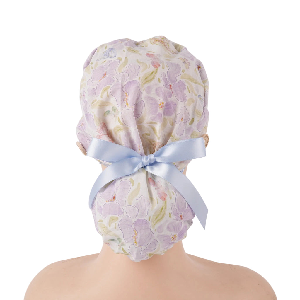 Lavender iris floral ponytail scrub cap with light blue ribbon bow, back view