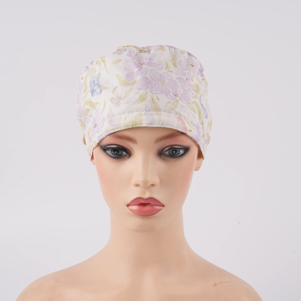 Lavender iris floral ponytail scrub cap displayed on a female mannequin head, front view.
