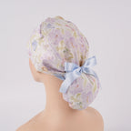Lavender iris floral ponytail scrub cap, displayed on a mannequin, side back view