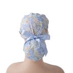 Ocean sea life ponytail scrub cap, shown on a mannequin head, back view with light blue ribbon bow.