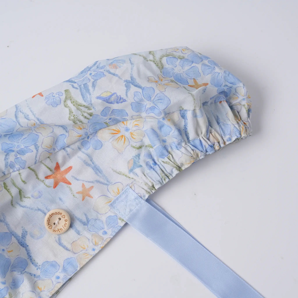 Sea life scrub cap close-up, elastic ponytail pouch and wooden button detail.