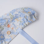 Sea life scrub cap close-up, elastic ponytail pouch and wooden button detail.