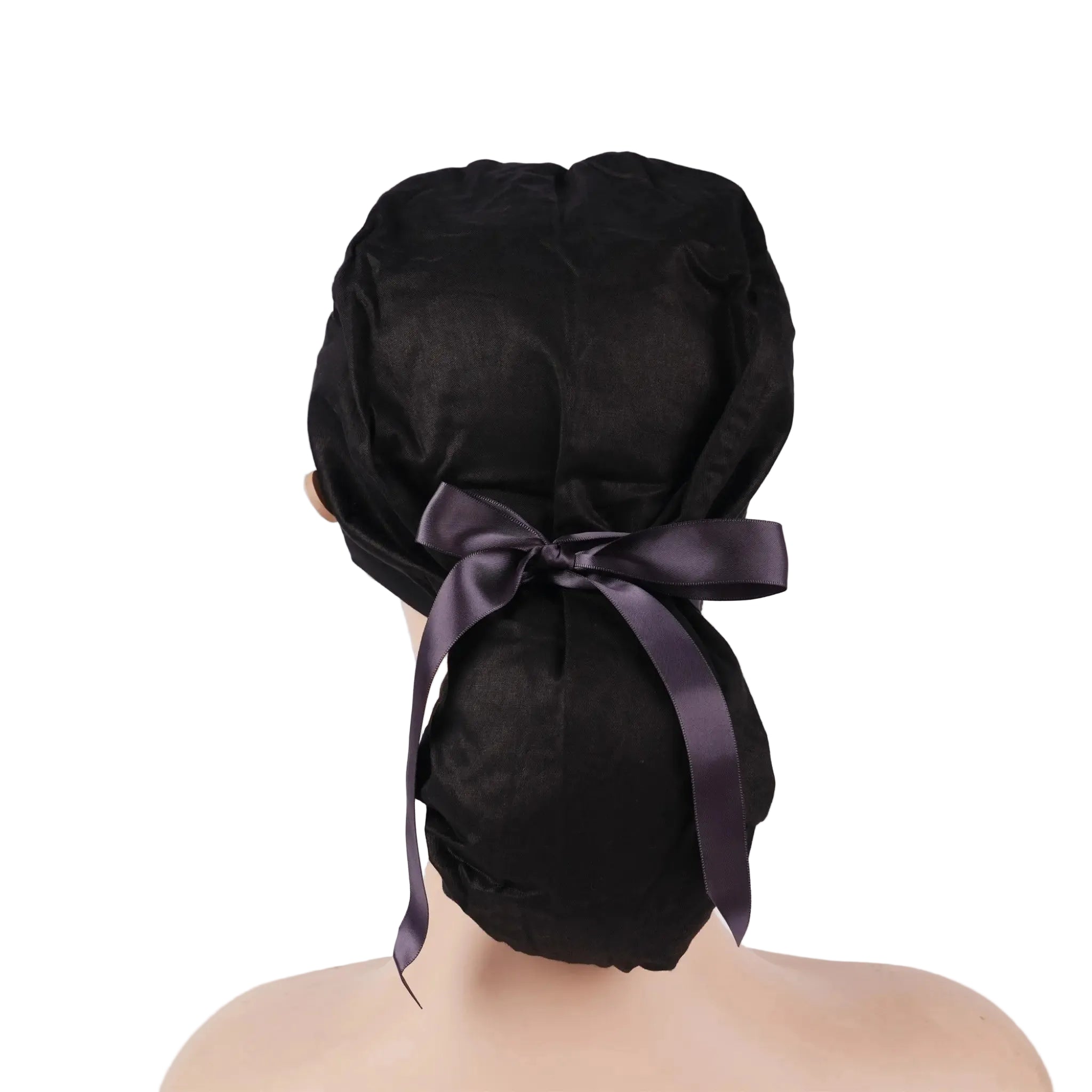 A solid black ponytail scrub cap shown from the back on a mannequin head, tied with black satin ribbon bow.