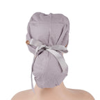 A solid gray ponytail surgical cap with a gray ribbon tied in a bow at the back, shown on a mannequin head.
