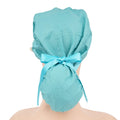 A teal ponytail surgical cap shown from the back on a mannequin head, tied with a matching color ribbon bow.