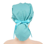 A teal ponytail surgical cap shown from the back on a mannequin head, tied with a matching color ribbon bow.