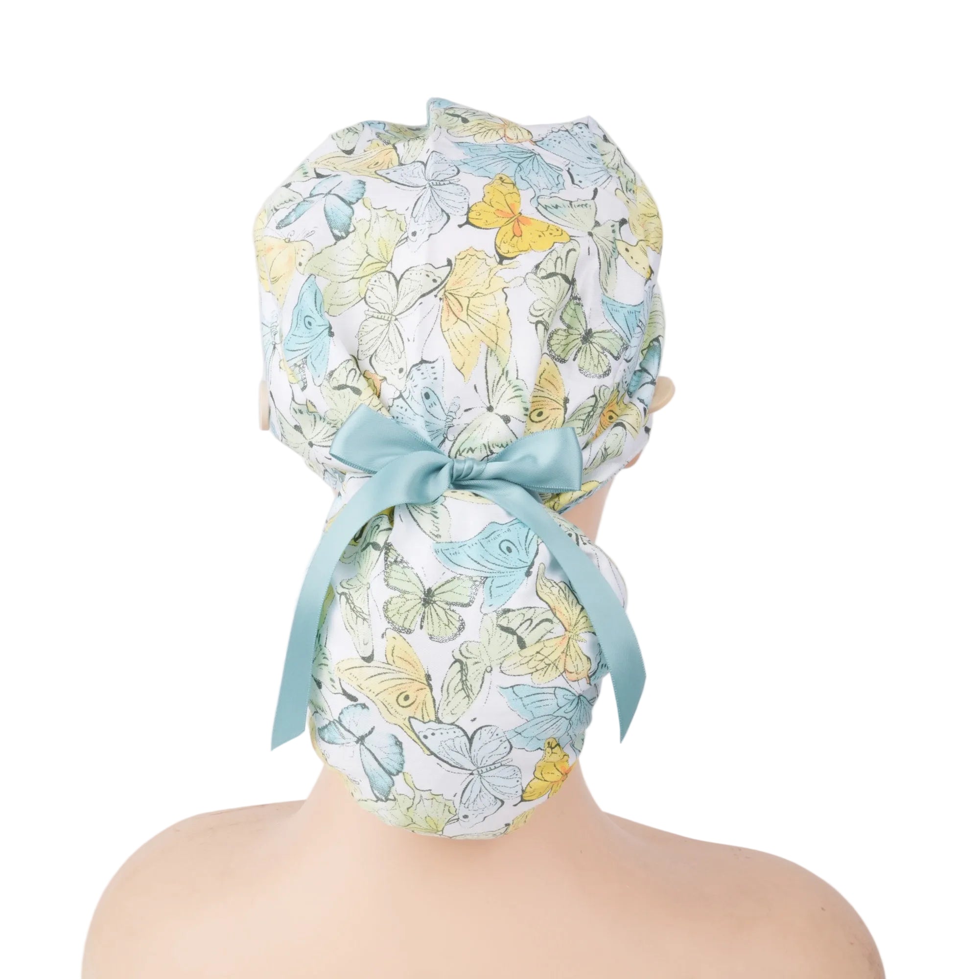 A ponytail surgical scrub cap, featuring pastel teal butterflies, finished with a matching satin ribbon bow.